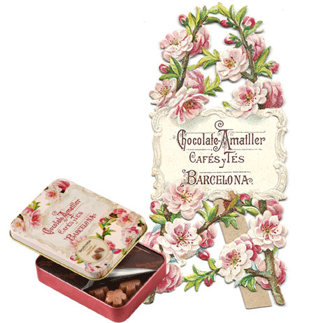 Cromo troquelat amb motius florals, publicitat de la Xocolata Amatller, present en els dissenys actuals dels estoigs de bombons de la marca.